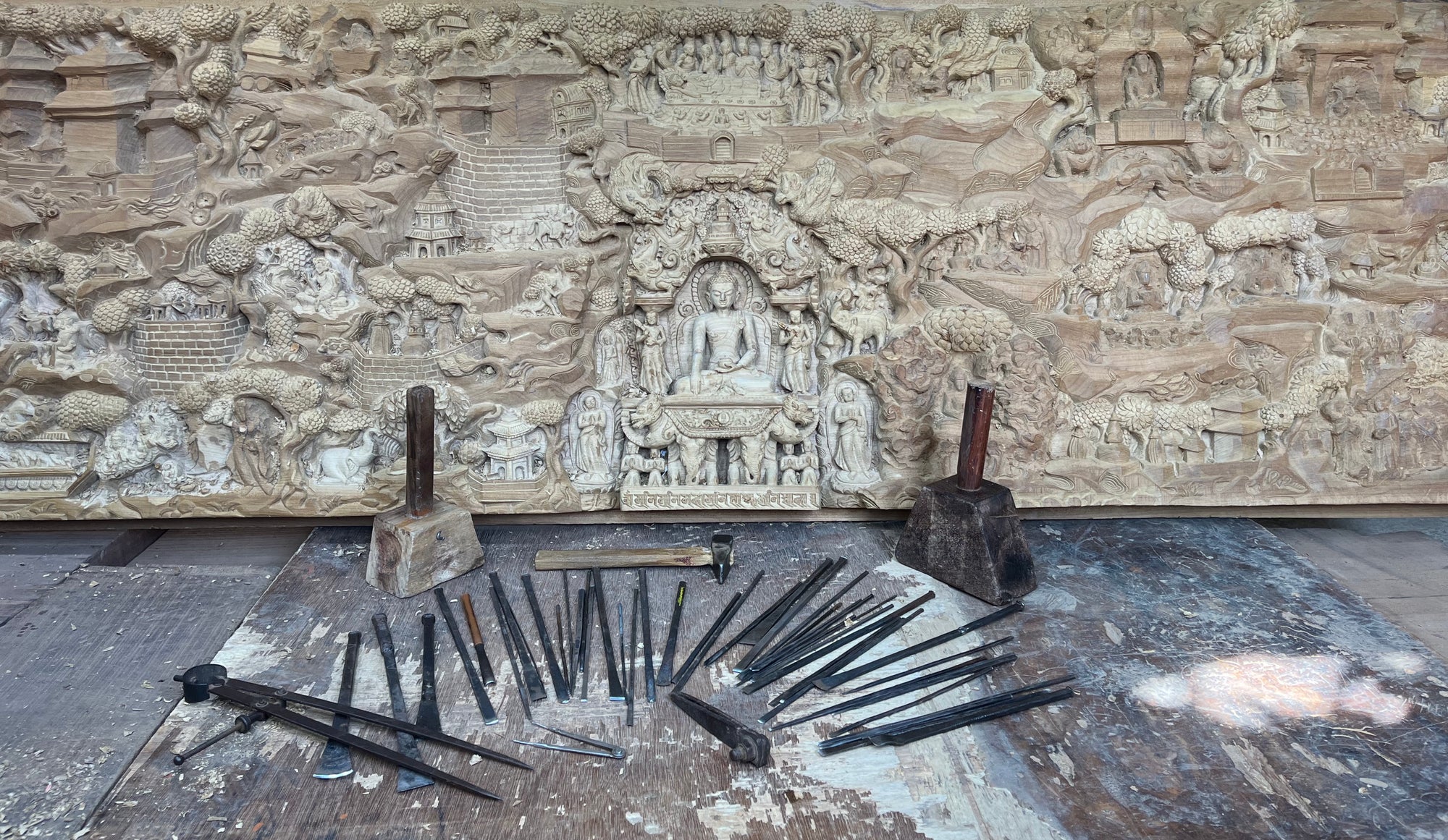 A panoramic relief of Buddha's life in the making in Bungmati, Nepal. Traditional carving tools, still in use today.