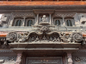 Original 10th–11th century wooden torana of Yetakha Baha Temple, depicting the Buddha teaching beneath a kirtimukha and flanked by makaras.
